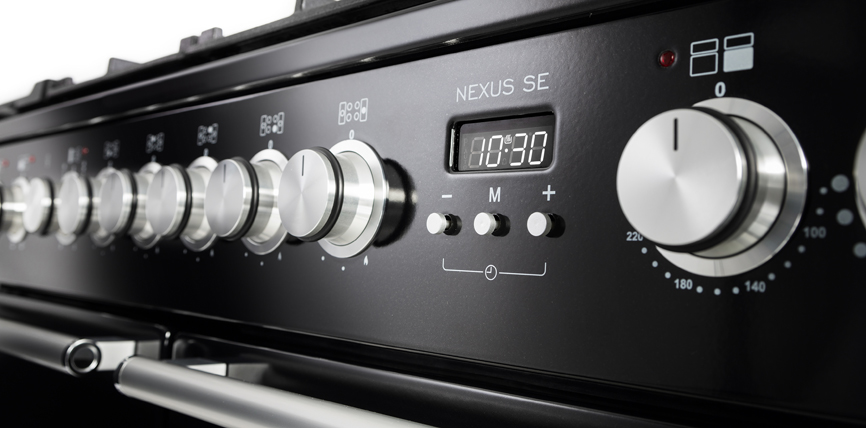 Nahaufnahme eines schwarzen Herdes vom Modell Nexus SE mit mehreren silbernen Drehknöpfen und digitaler Anzeige