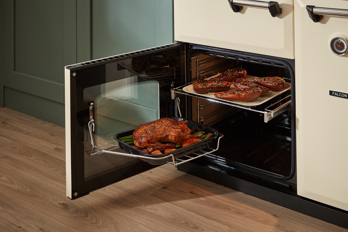 Falcon Range Cooker in Creme: geöffneter Backofen mit Teleskopauszug und Bratreine, ideal zum Braten von Hähnchen und Gemüse