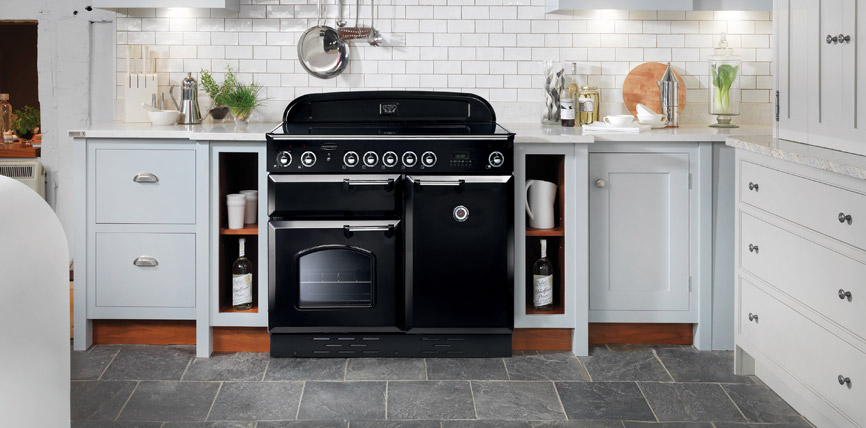 Großer schwarzer Standherd mit Backofen in einer hellen, modernen Landhausküche mit grauen Schränken, Fliesenrückwand und Küchenutensilien.