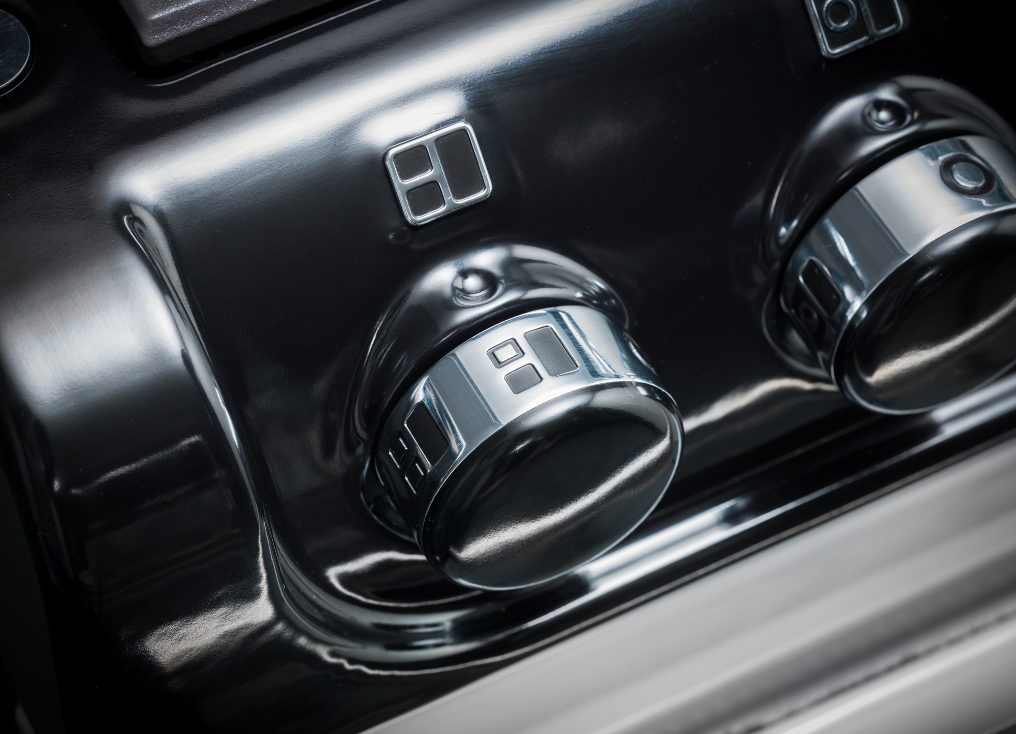 Detailansicht von silbernen Steuerknöpfen an einem hochwertigen Küchengerät, wahrscheinlich Herd oder Backofen