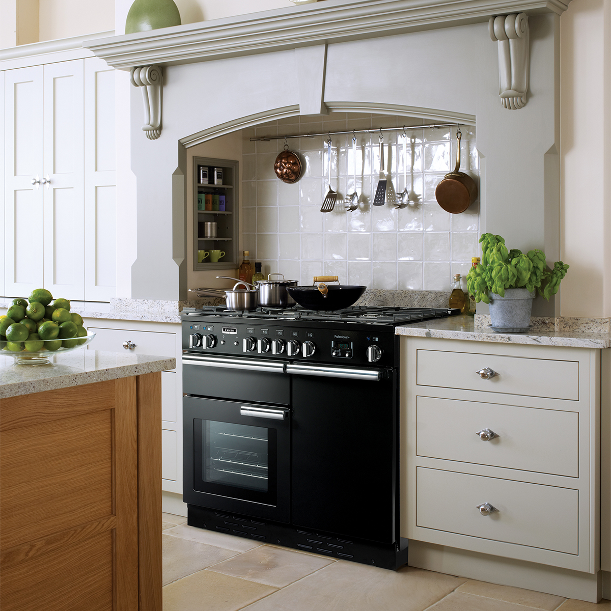 Schwarzer Herd in eleganter Landhausküche mit Utensilien, Töpfen und Kräutern auf Granit-Arbeitsflächen