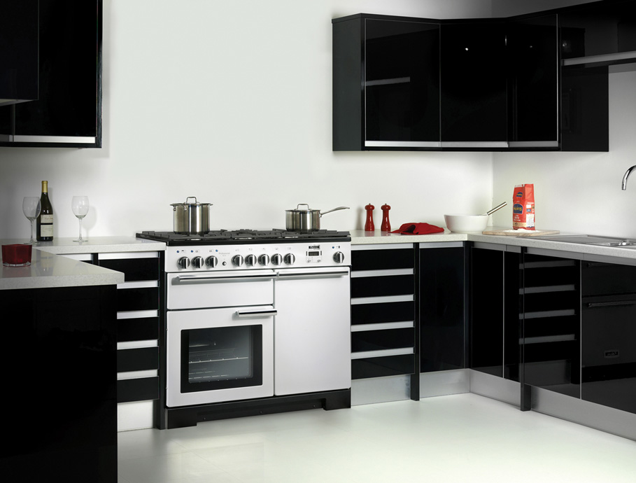 Moderne Küche mit weißem Herd, schwarzen Hochglanzschränken, Edelstahltöpfen und Küchenutensilien auf der Arbeitsfläche