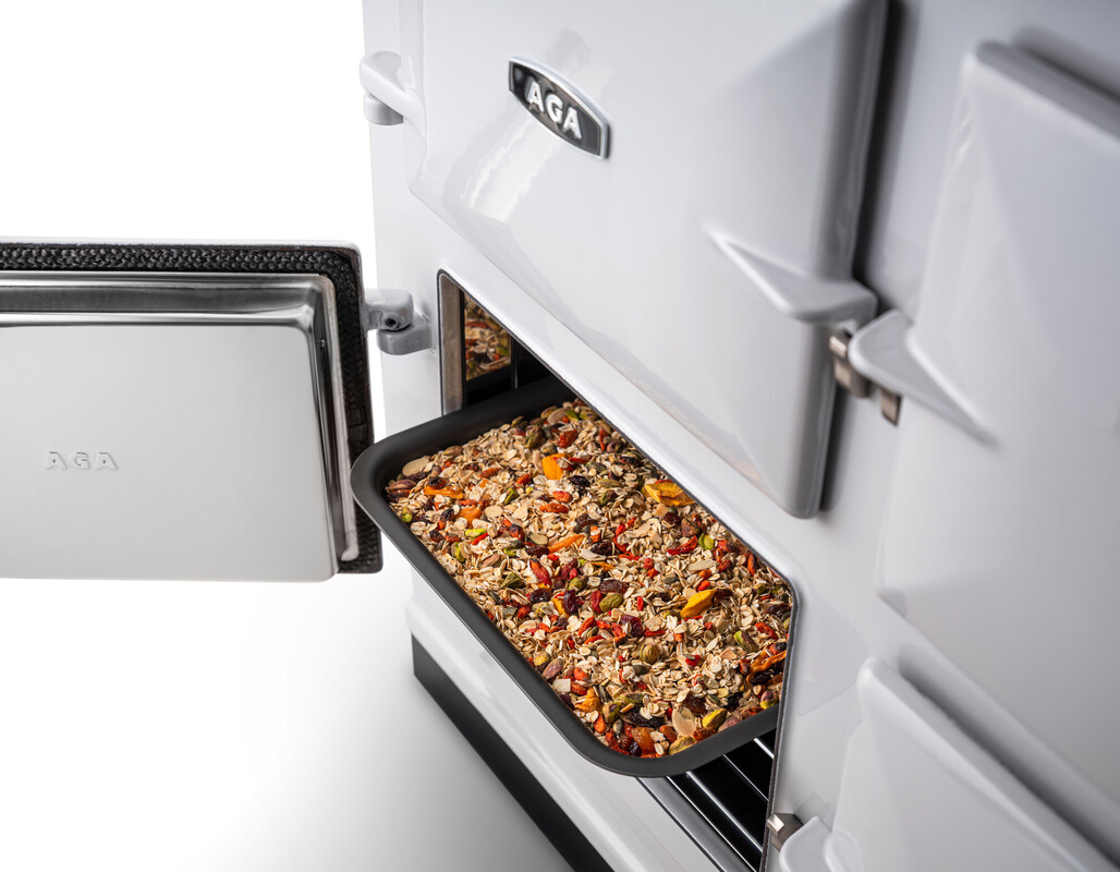 Ein Backblech mit einem Müsliriegel-Mix wird im geöffneten AGA-Backofen gebacken