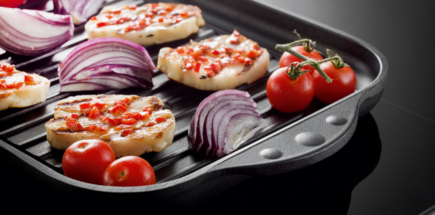 Halloumi-Käse mit Paprikastückchen, rote Zwiebeln und Tomaten auf einer Grillpfanne